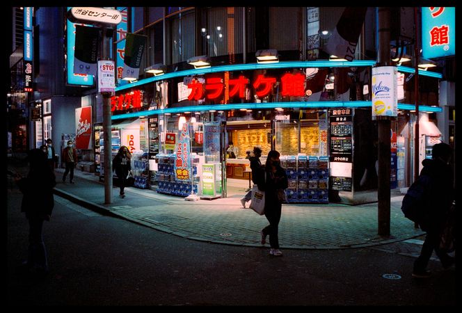 People walking down the street at nighttime in Japan
