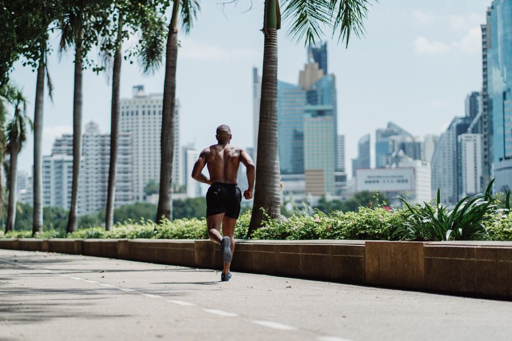Back view of topless man running on road