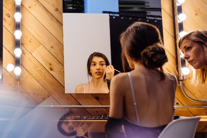Glamorous female applying lipstick