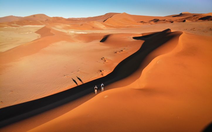 Two people walking on desert in Namib, Erongo, Namibia