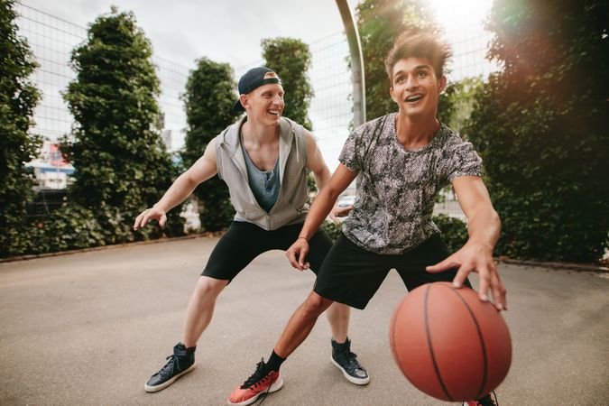 Happy men playing basketball