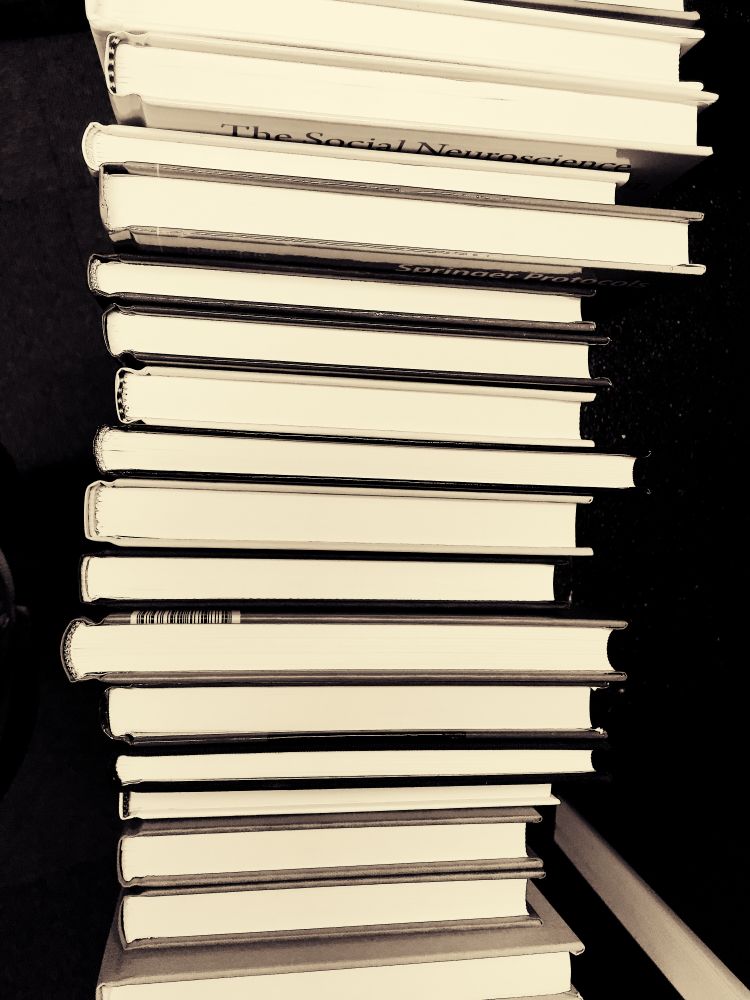 Stack of books in against dark background in grayscale
