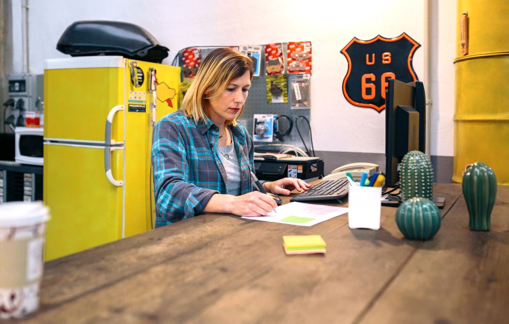 Blonde young woman checking orders received by ecommerce shop