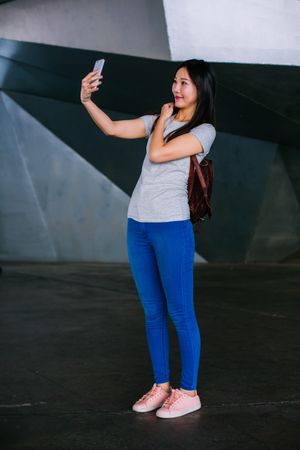 Asian female taking selfie in underground passage