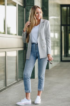 Woman in blazer walking outside offices