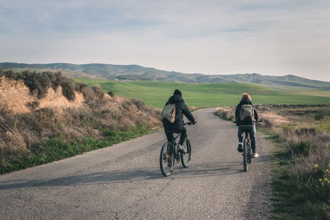 Men riding bicycles on road in desert hills