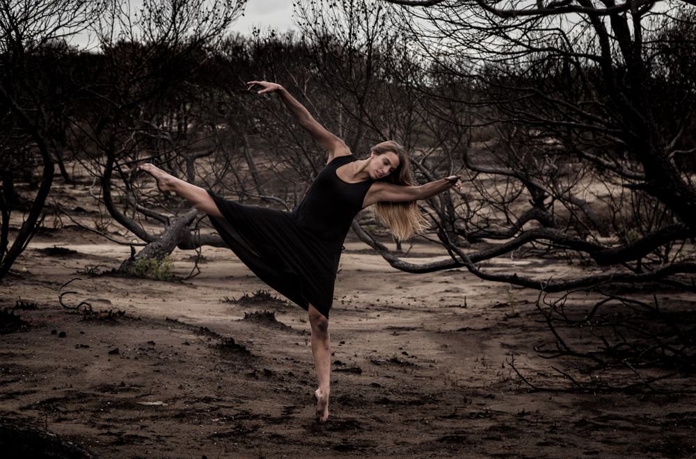 Woman dancing between dry trees