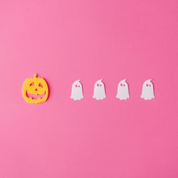 Row of pumpkin with ghosts on pink background