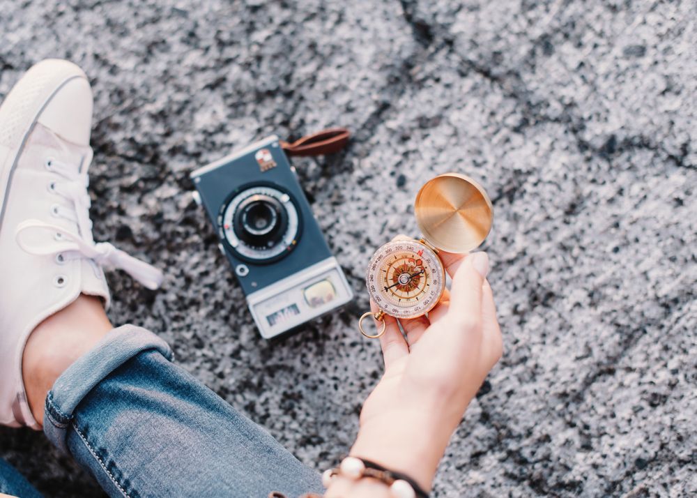 Woman with compass founding route fro photography trip