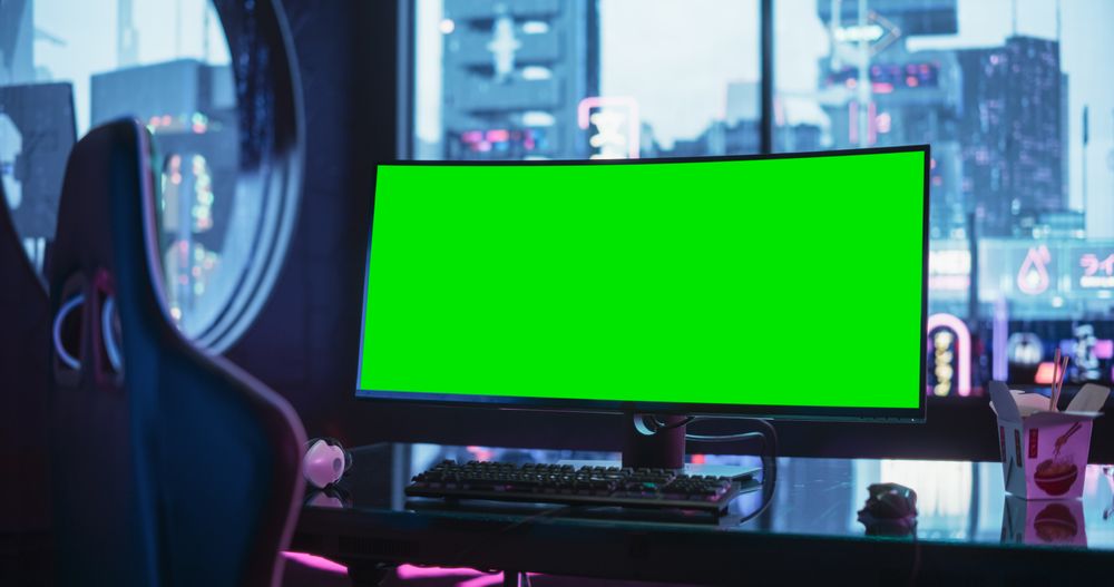 Professional Video Game Computer with Green Screen Mock Up Display Standing on a Stylish Table in a Futuristic Cyberpunk Room with Neon Light