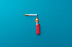 One red lighter and one cigarette on blue background