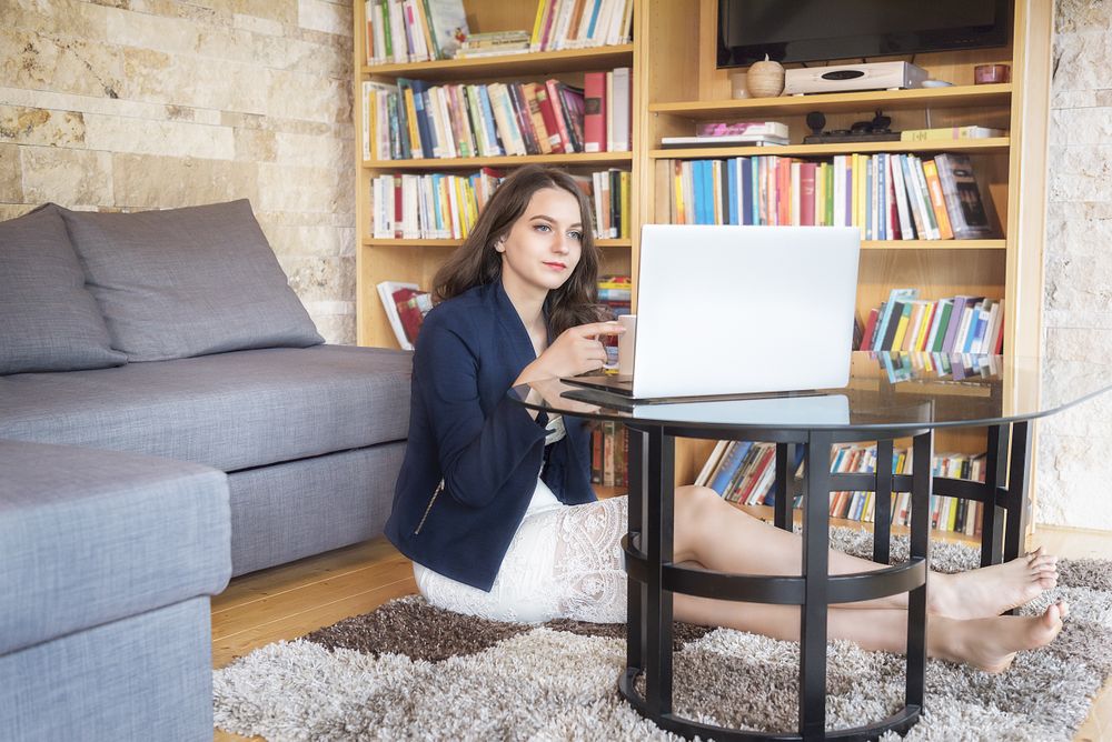 Smiling woman using a laptop at home