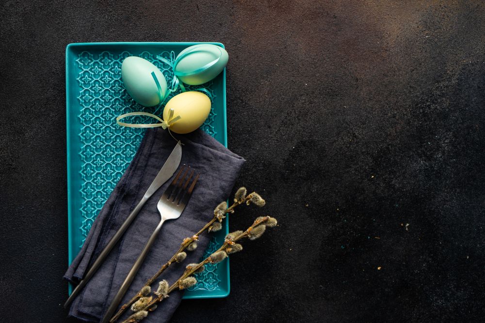 Easter table setting with eggs and pussy willow on rectangular plate
