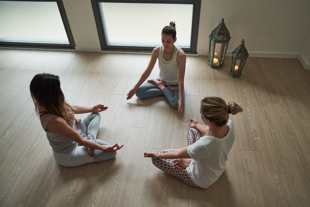 Group of females doing Padmasana exercise in spacious room