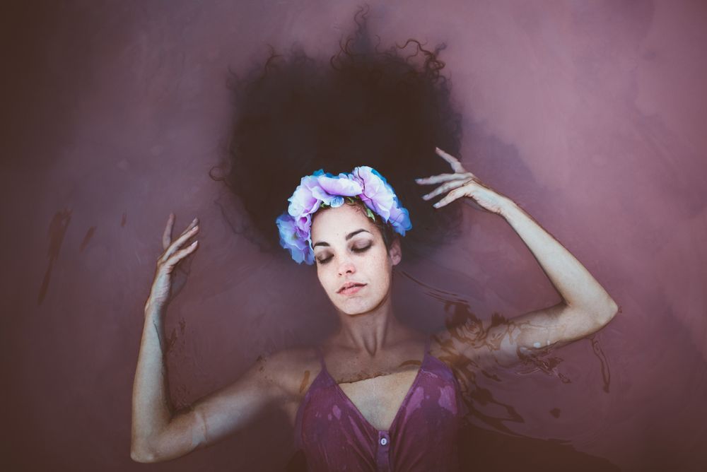 Woman with wreath lying in water