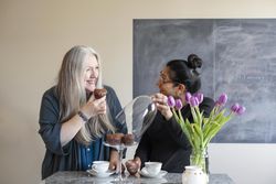 Two happy women eat chocolate muffins