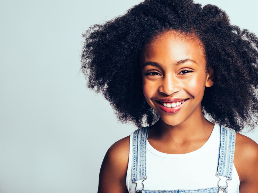 Portrait of happy girl smiling in jean overalls