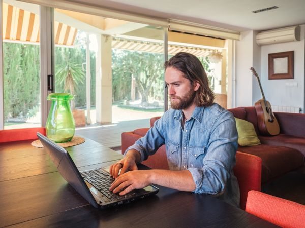 Focused man using computer in apartment