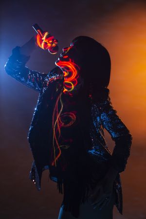 Stylish woman singing on stage