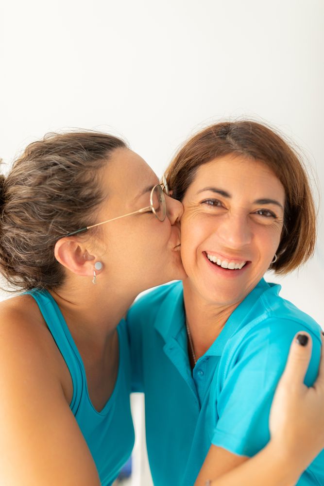 A woman gives a kiss to her physiotherapist friend, after receiving a massage at the physiotherapy clinic