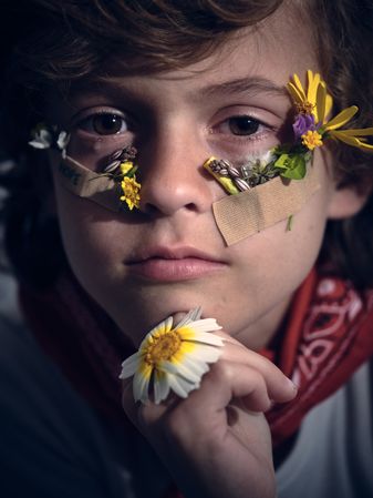 Cute boy with wildflowers on face