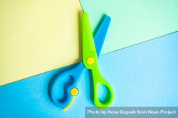 Blue & green children's scissors on paper background 4ZeO91