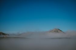 Wonderful view of blue sky above white thick clouds in valley from mountain