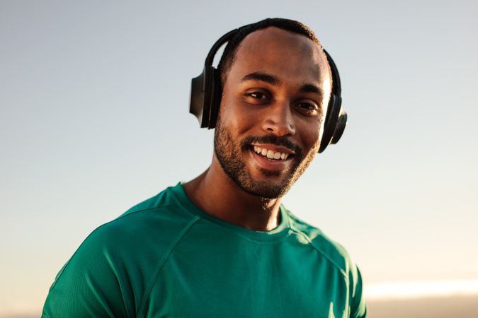 Close up of a man standing outdoors listening to music
