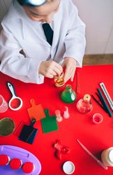 Little boy scientist mixing liquid in bottle