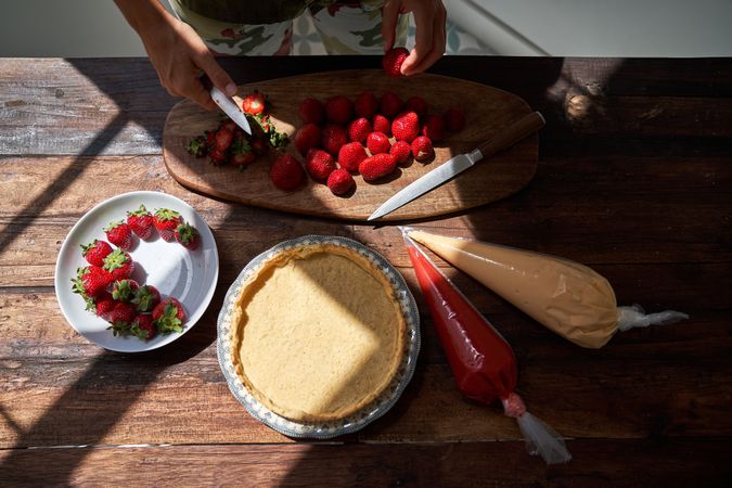 Faceless person cooking pie with strawberries