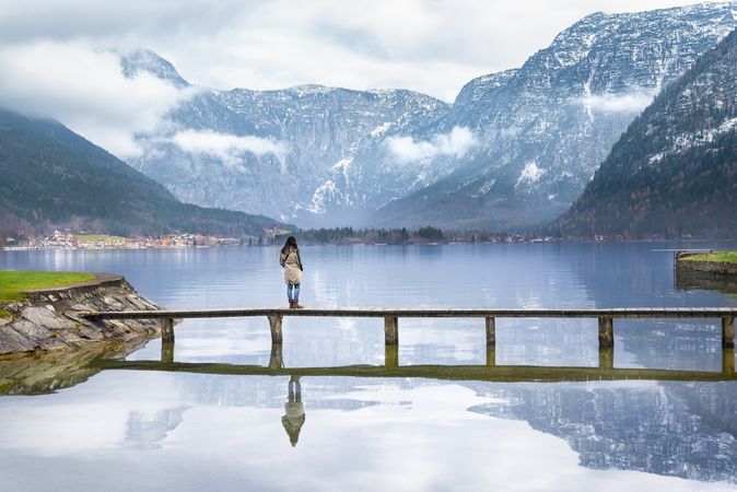 Woman standing on deck over peaceful alpine lake