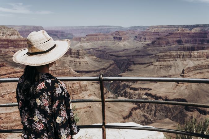 Tourist gazing while standing on edge of picturesque canyon