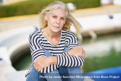 Portrait of older female relaxing on dock on sunny day 42Vv74