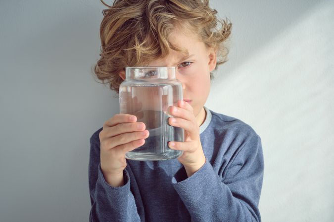 Blond haired boy with jar of water