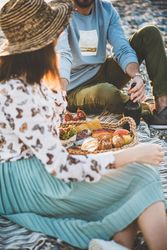 Two people at summer picnic outdoors with wine