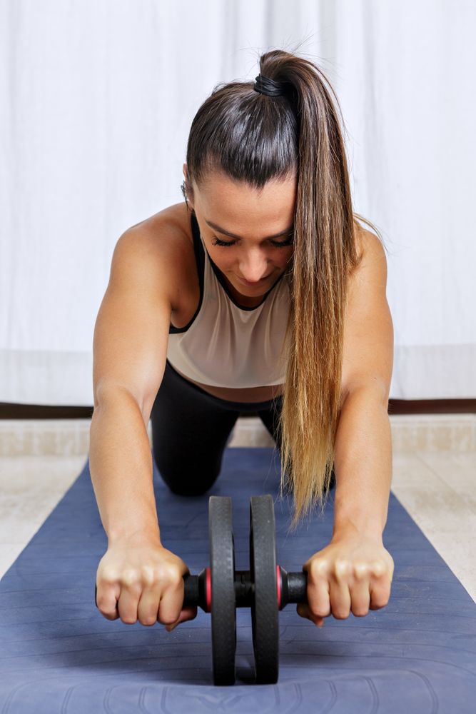 Young exercising the core using wheel
