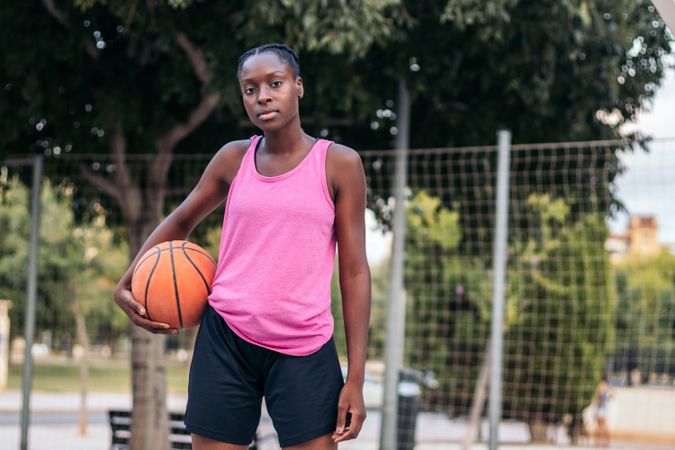Confident Basketball Player Holding Ball with Determination