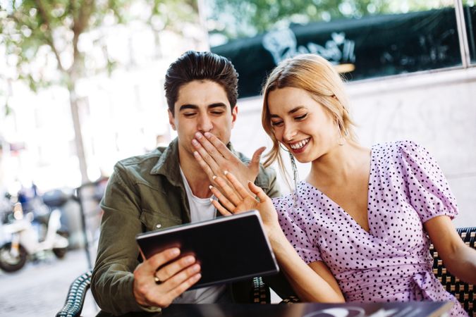 Happy young couple using tablet outdoors