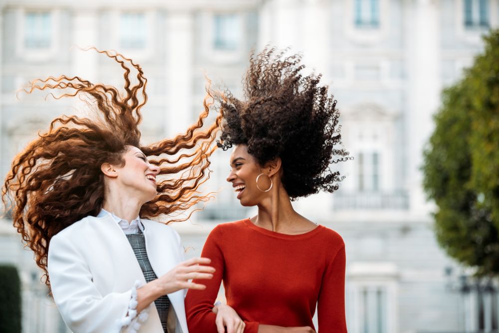 Two cheerful young women walking together