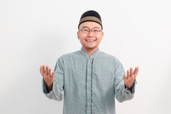 Asian Muslim man smiling doing greeting pose during Ramadan