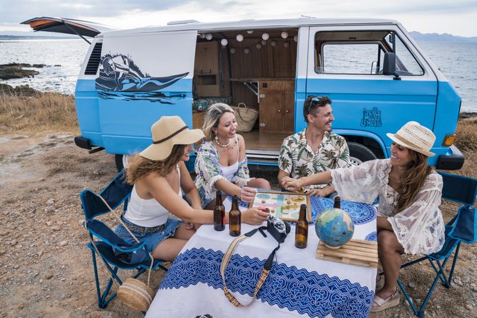 group of friends sitting in chairs next to a minivan