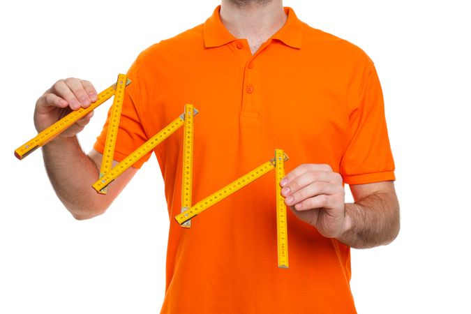 Young man civil engineer with measuring roulette isolated on light background