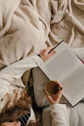 Person reading a book on the bed