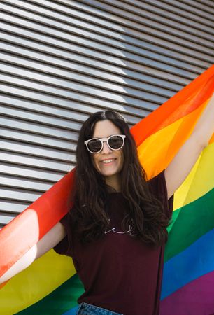 Woman posing happily with the LGBT flag