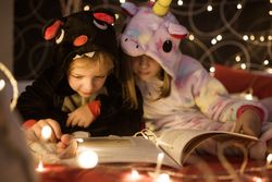 Kids reading Christmas fairy tales in bed