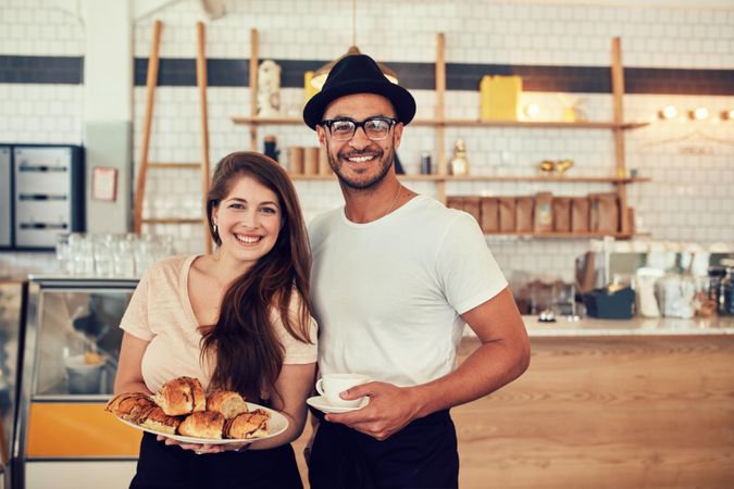 Portrait of happy young man and woman with food and cafe at coffee shop