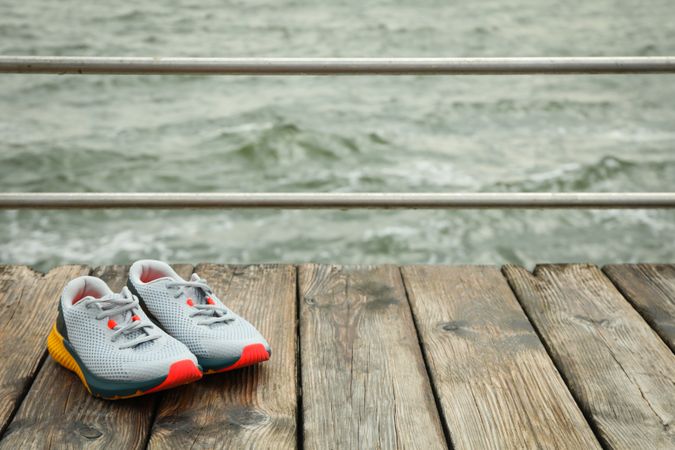 Sneakers on wooden floor outdoors, space for text