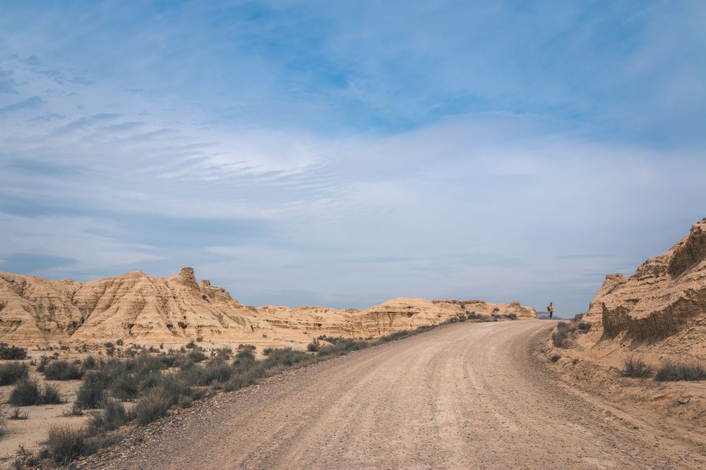 Man walking on road in desert hills