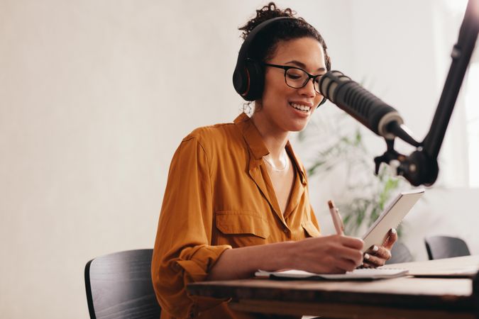 Young woman recording podcast using microphone