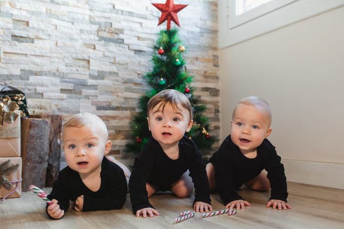 Happy babies near Christmas tree and gifts